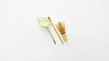 Bambu çırpıcı ve chashaku bambu kaşığı beyaz arka planda kibrit yeşil çay ve yaprak için.