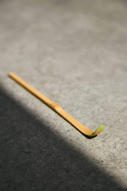 Kibrit çayı için Chashaku bambu kaşığı ve gri bir taş yüzeyde bir köşe gölgesi..