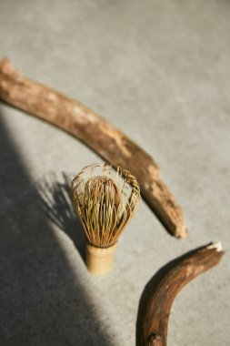 Kibrit çayı için bambu çırpıcı ve gri arka planda gölgeli tahta çubuklar.. 