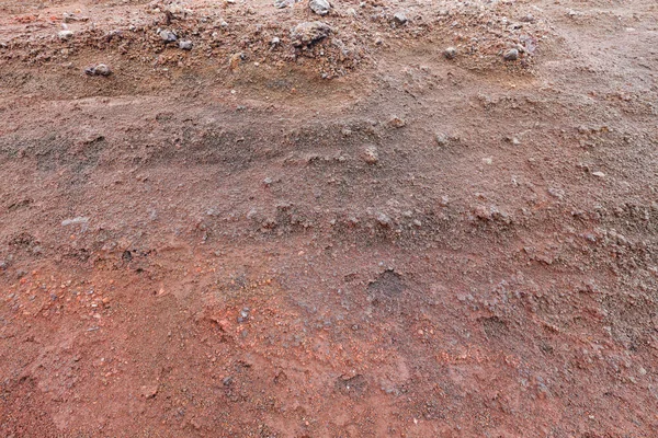 A cut of soil with rocks and red soil — Stock Photo, Image