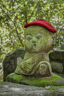 Jizo taş heykeli örgü ve kumaştan şapkalar giyiyor..