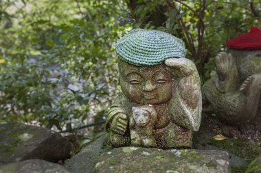 Maymun - Japon burcunun sembolü. Jizo taş heykeli örgü ve kumaştan şapkalar giyiyor..