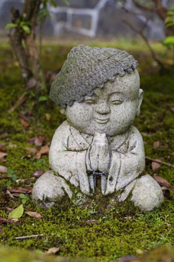 Jizo taş heykeli örgü ve kumaştan şapkalar giyiyor..