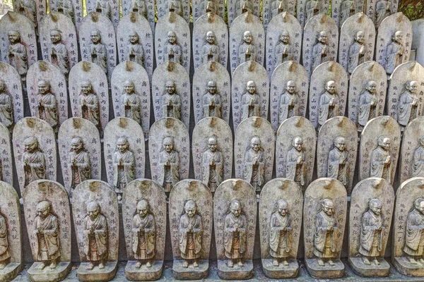 Маленькі кам'яні статуї біля стародавньої японської святині — стокове фото