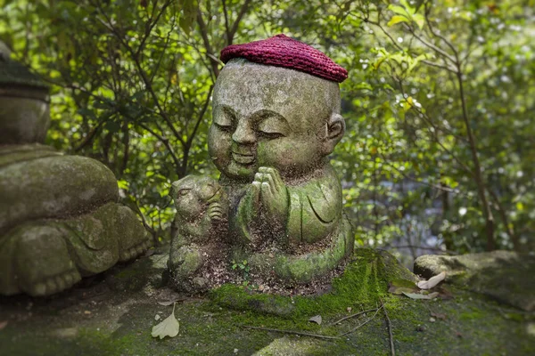 Králík - symbol japonského horoskopu. Dětská kamenná socha Jizo v pletených a plátěných čepicích se zvířetem zvěrokruhu. — Stock fotografie