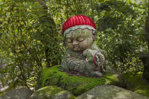 La oveja - el símbolo del horóscopo japonés. Estatua de piedra de Jizo con sombreros de punto y tela . — Foto de Stock
