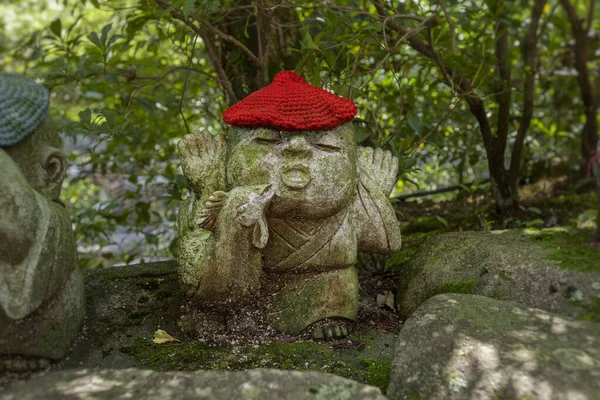 El gallo - el símbolo del horóscopo japonés. Estatua de piedra de Jizo con sombreros de punto y tela . — Foto de Stock