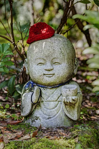 Jizo kamenná socha v pletených a plátěných čepicích. — Stock fotografie