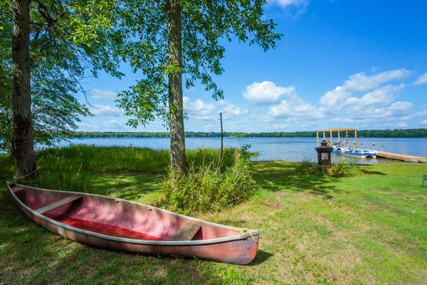 Červené kanoe na pláži jezera. — Stock fotografie