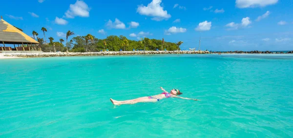 Woman floating on a back in the beautiful sea. Aruba island — Stock Photo, Image