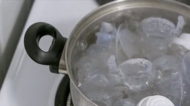 Kaynar suda bir göğüs pompası ve bebeklerin süt şişe sterilize