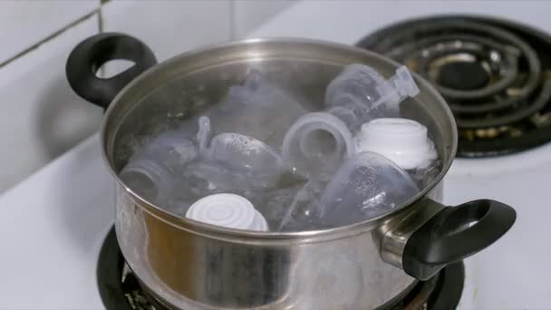 Steriliseren van een borst pomp en baby's melkflessen in kokend water — Stockvideo