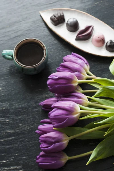 Strauß Tulpen, schwarzer Kaffee und leckere Süßigkeiten — Stockfoto