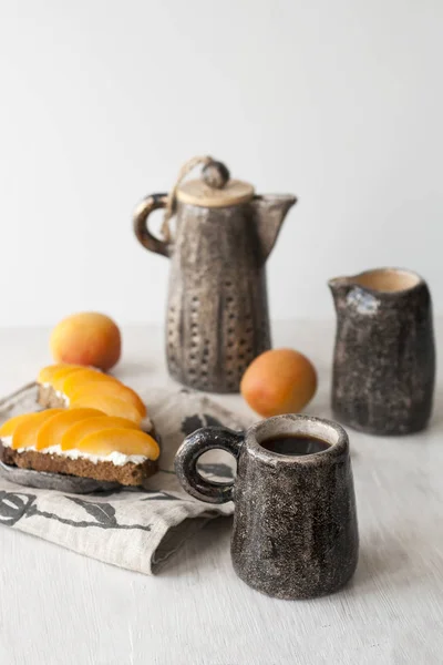 Бутерброди з солодким сиром і абрикосами, чай і чашка — стокове фото