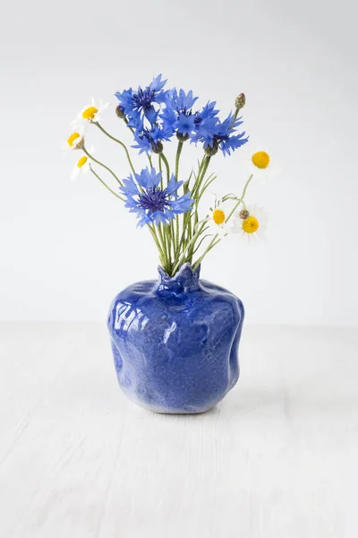 Buquê de flores silvestres em um vaso azul — Fotografia de Stock