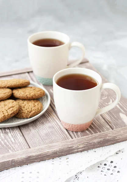 A tasty snack: two cups of tea and a plate of cookies. — ストック写真