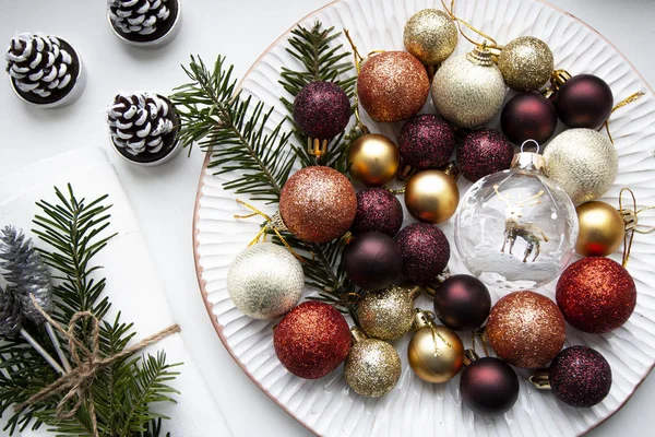 Decoraciones de colores navideños yacen en un plato blanco —  Fotos de Stock