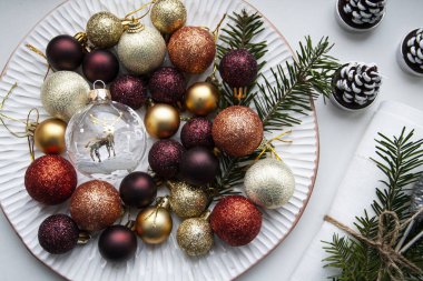 Noel süslemeleri beyaz bir tabakta duruyor.