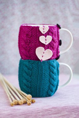 Pembe ve mavi kazaklı iki kupa teke tek duruyor.. 