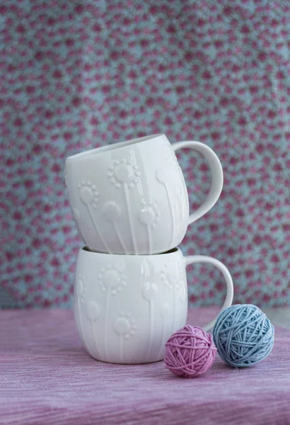 Two white cups stand on top of each other on a pink background, — Stock Photo, Image