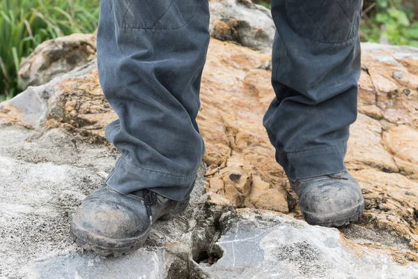 Треккинг кожаный ботинок на скале — стоковое фото