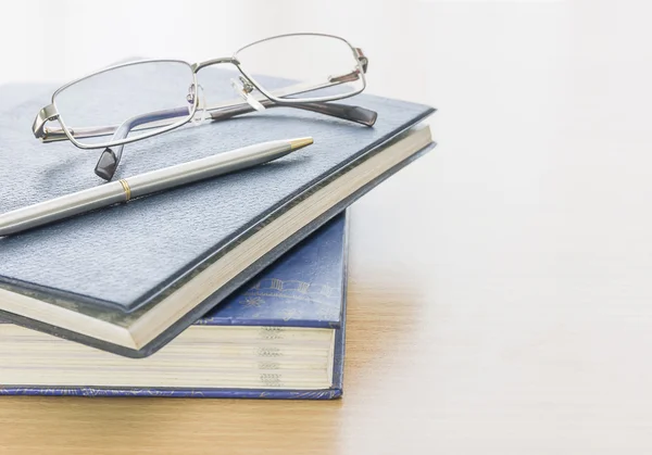 Zwartboek met glazen en pen — Stockfoto