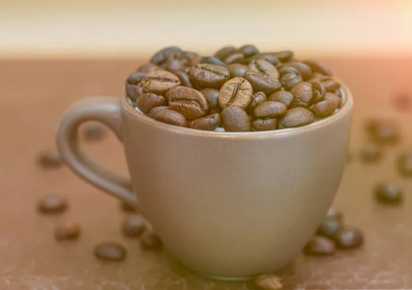 Жареные кофейные зерна в коричневой чашке кофе — стоковое фото