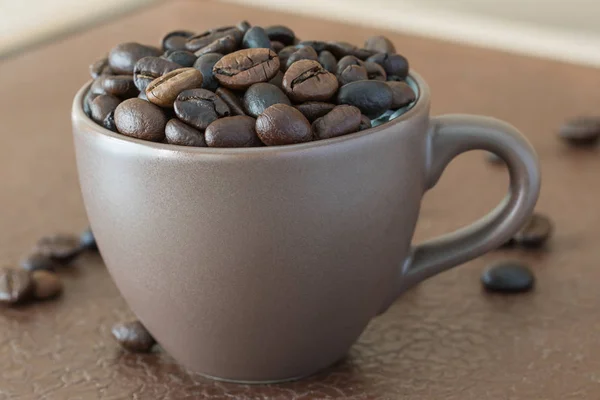 Grains de café torréfiés dans une tasse de café — Photo