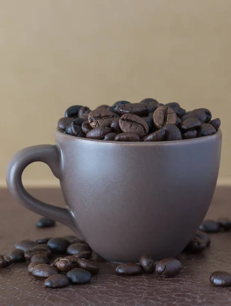 Grãos de café torrados em xícara de café marrom — Fotografia de Stock