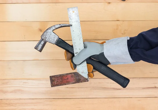 Mano en guante sosteniendo regla de hierro y martillo —  Fotos de Stock