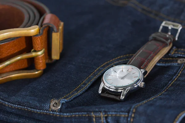 Pols horloge en lederen riem op jeans — Stockfoto
