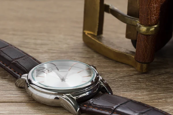Armbanduhr und brauner Ledergürtel — Stockfoto