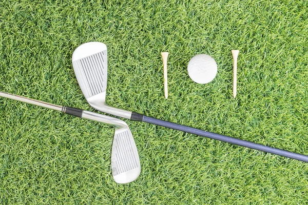 Golf club and golf ball on green grass