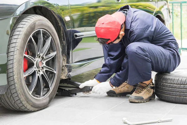 Mekaniker som ersätter flänsmuttrar byta däck på fordonet — Stockfoto