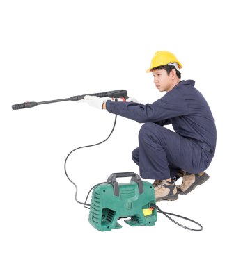 Oturma ve yüksek basınçlı su silah tutan genç adam