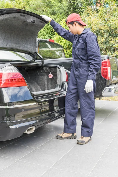 Mechanic replacing to the spare tire at the back of the car — Stock Photo, Image