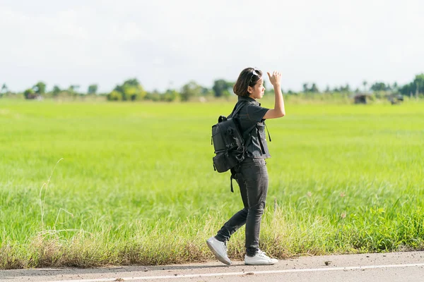 Frau mit Rucksack trampt auf Straße — Stockfoto