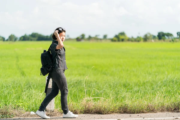 Frau mit Rucksack trampt auf Straße — Stockfoto