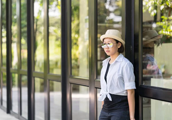 Mujeres con sombrero de pie frente a un edificio de vidrio —  Fotos de Stock