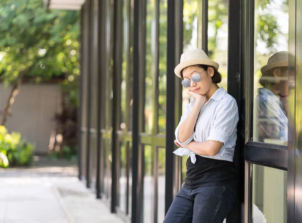 Mujeres con sombrero de pie frente a un edificio de vidrio —  Fotos de Stock