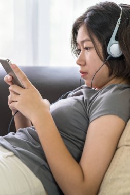 Asyalı kadın cep telefonu üzerinden müzik dinleme