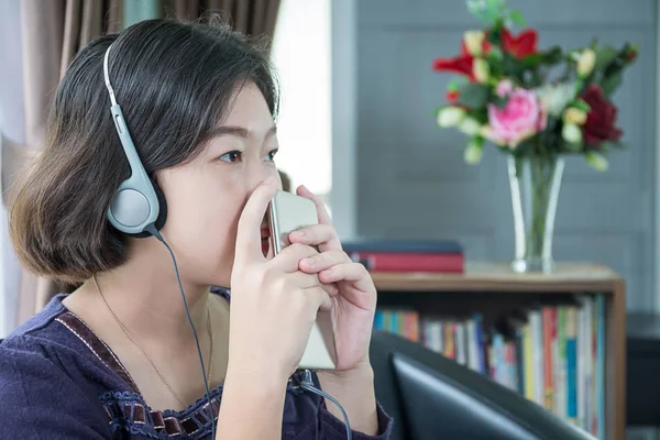 Joven mujer asiática pelo corto escuchando música en la sala de estar —  Fotos de Stock