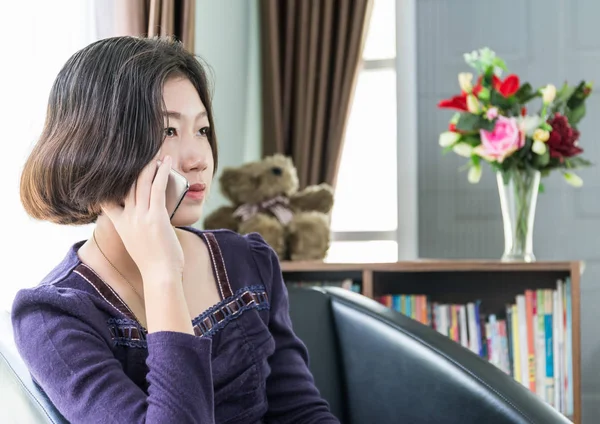 Genç Asyalı kadın kısa saç oturma odasında cep telefonu kullanın — Stok fotoğraf