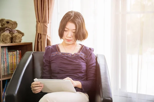 거실에서 휴대 전화를 사용 하는 젊은 아시아 여자 짧은 머리 — 스톡 사진