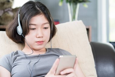 Asyalı kadın cep telefonu üzerinden müzik dinleme