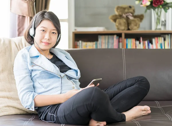 Kvinna kort hår lyssnar musik i vardagsrummet — Stockfoto