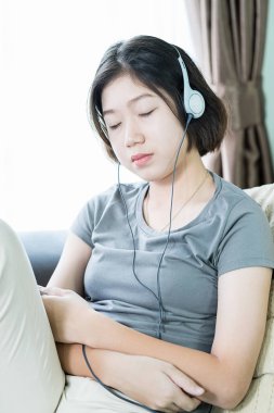 Cep telefonundan müzik dinleyen genç bir kadın.