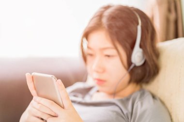 Asyalı kadın cep telefonu üzerinden müzik dinleme
