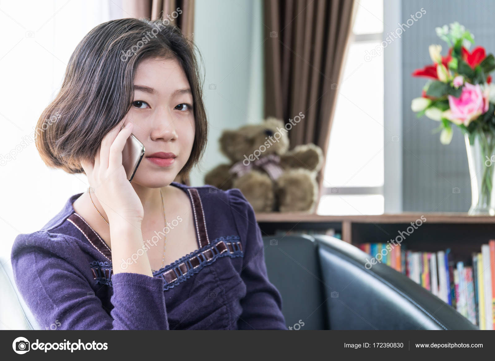 Young Asian Woman Short Hair Use Mobile Phone In Living Room