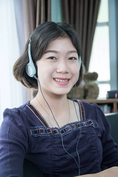 Ung asiatisk kvinna kort hår lyssnar musik i vardagsrummet — Stockfoto
